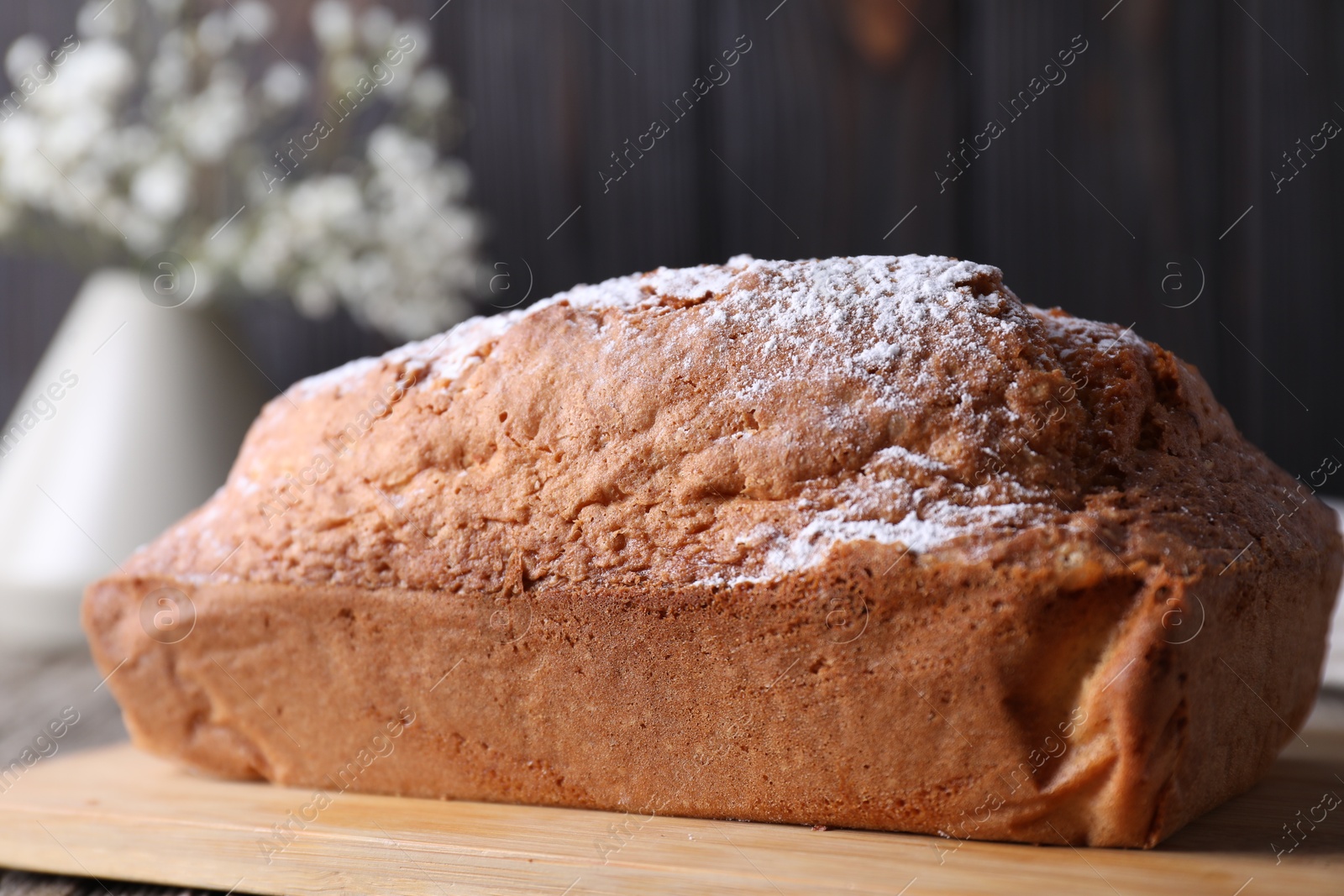 Photo of Tasty sponge cake with powdered sugar on table, closeup