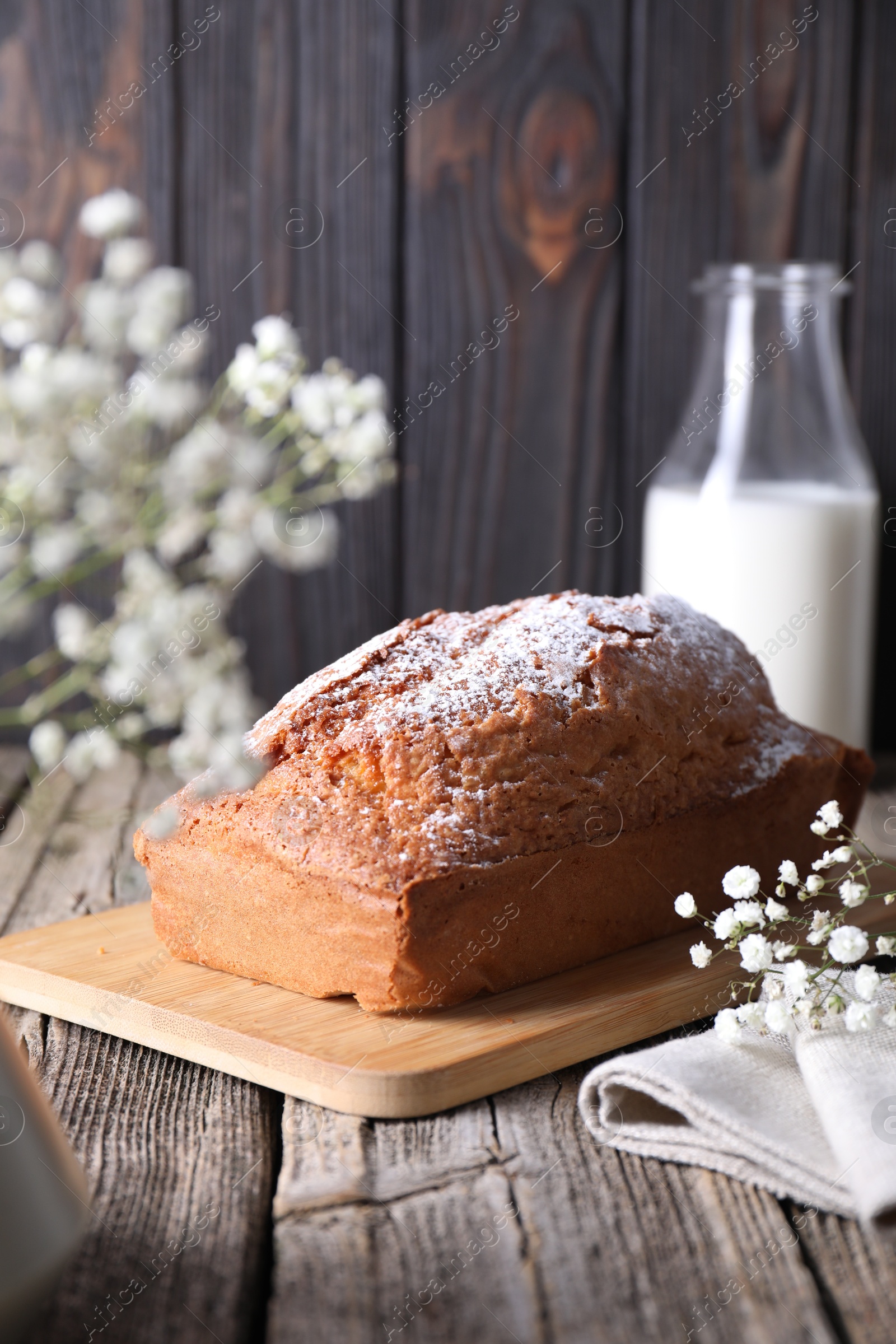 Photo of Tasty sponge cake with powdered sugar on wooden table