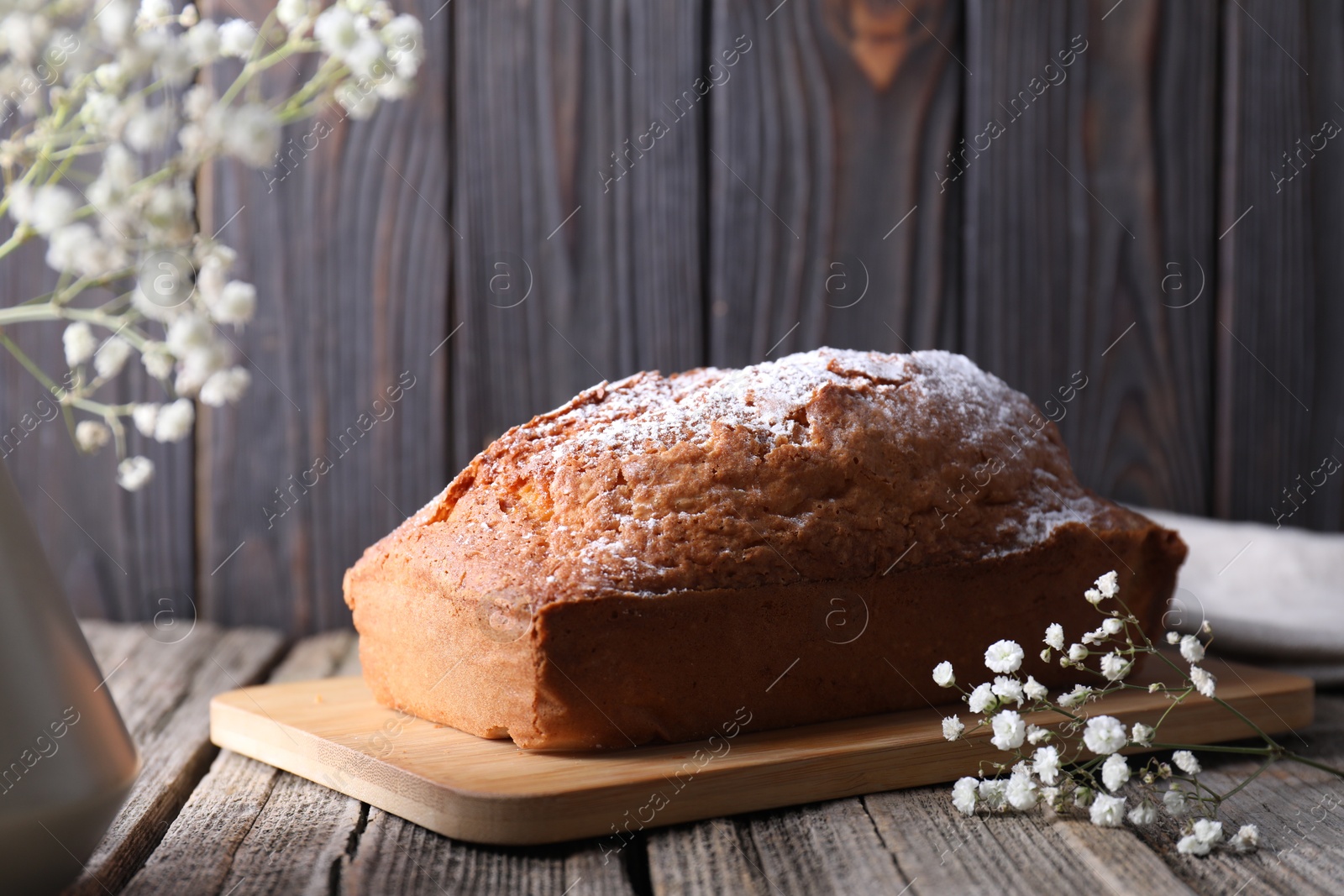 Photo of Tasty sponge cake with powdered sugar on wooden table