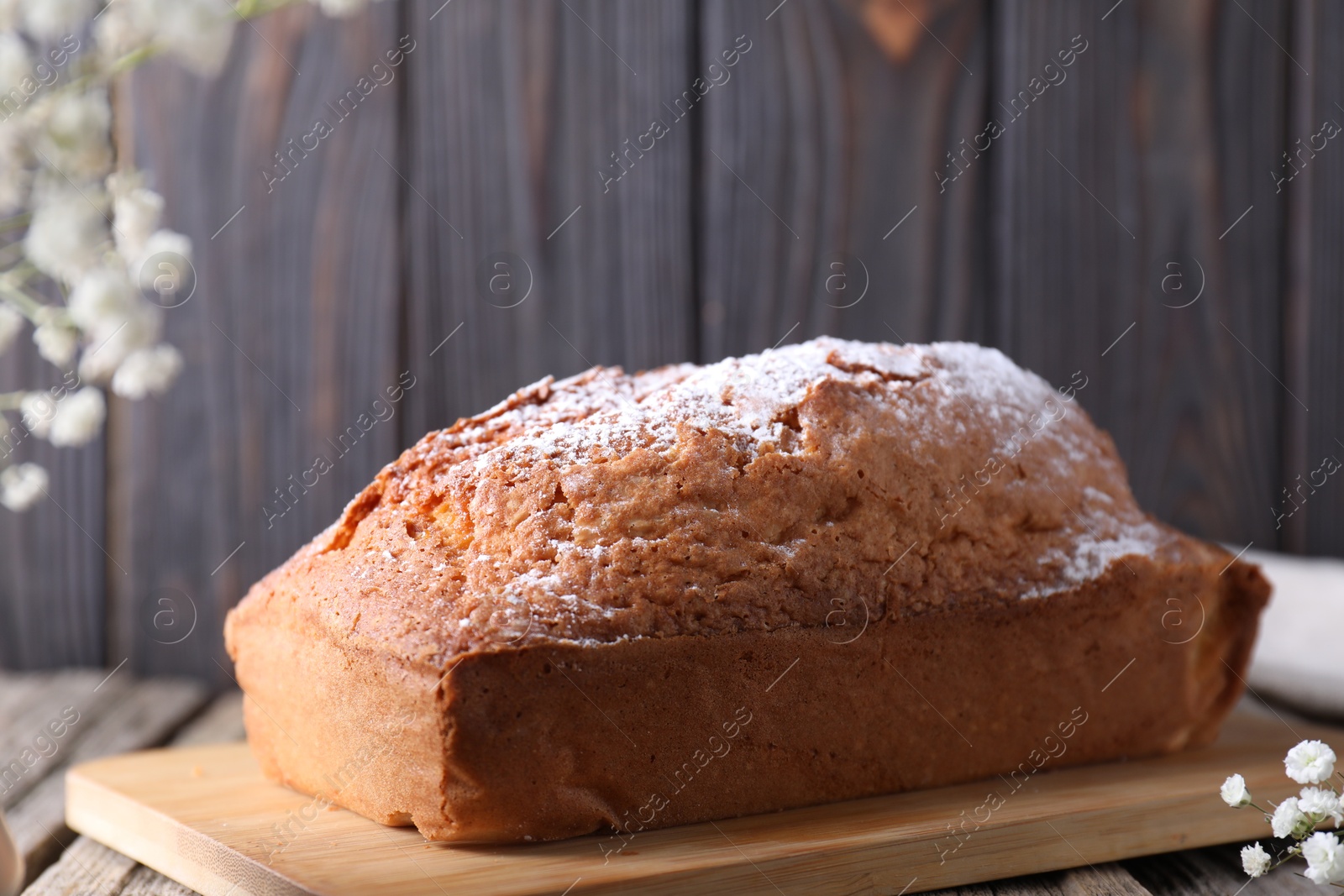 Photo of Tasty sponge cake with powdered sugar on table, closeup