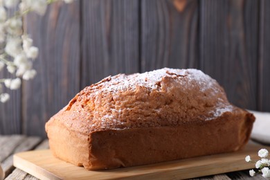 Photo of Tasty sponge cake with powdered sugar on table, closeup