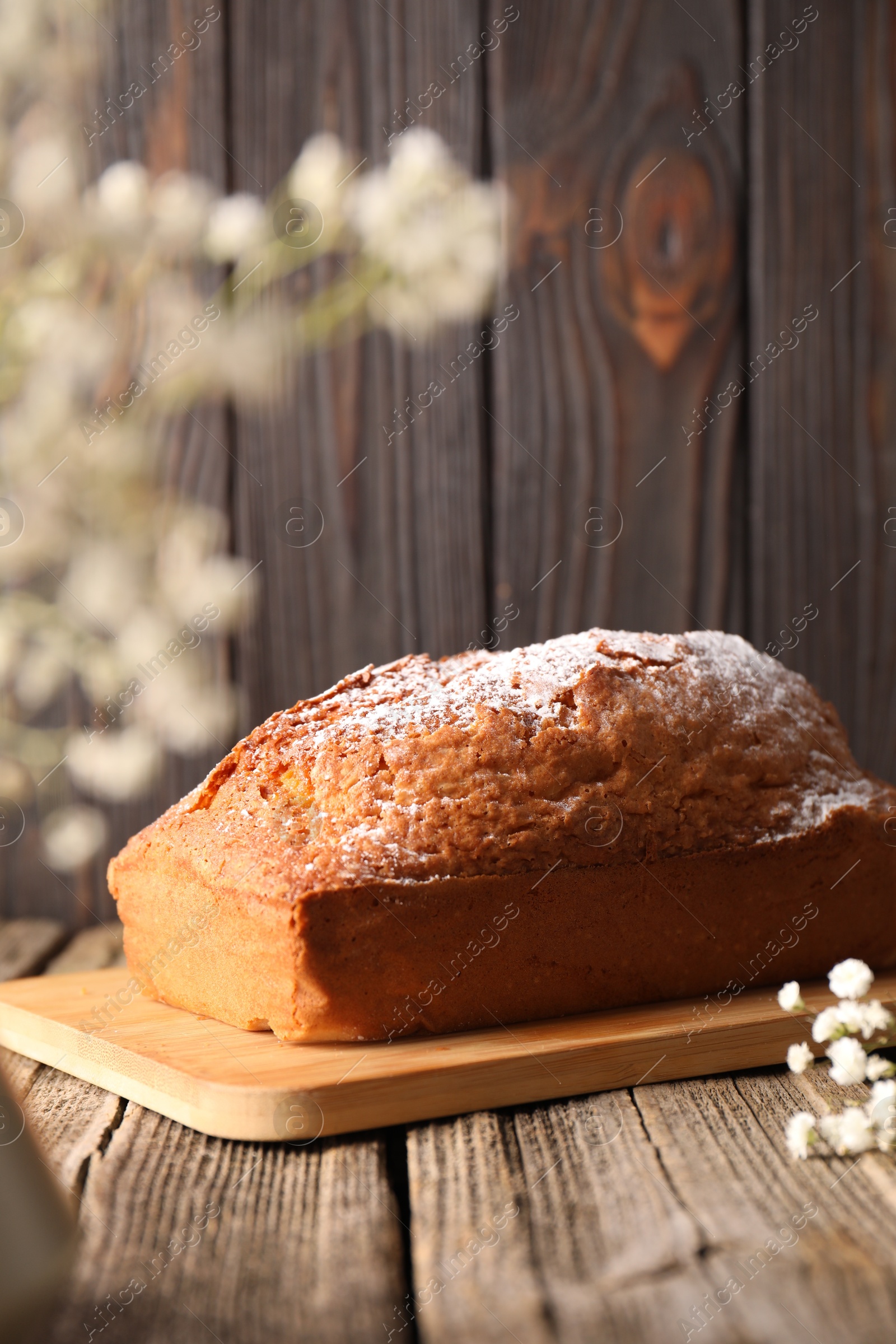 Photo of Tasty sponge cake with powdered sugar on wooden table