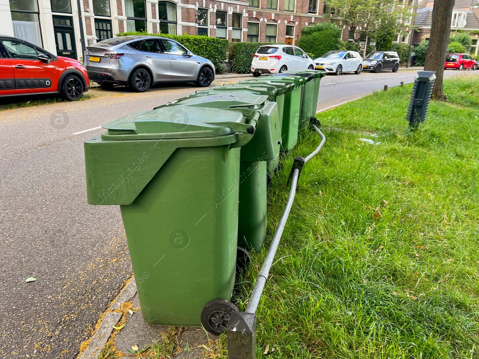 Photo of Many green trash bins on city street