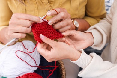 Photo of Mother and daughter knitting new pattern, closeup