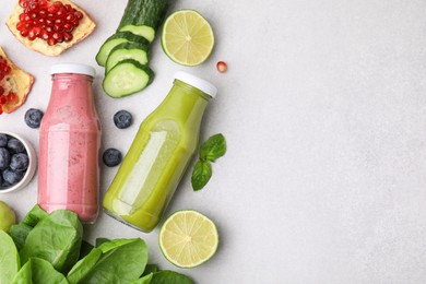 Photo of Glass bottles of tasty smoothies and different products on white table, flat lay. Space for text