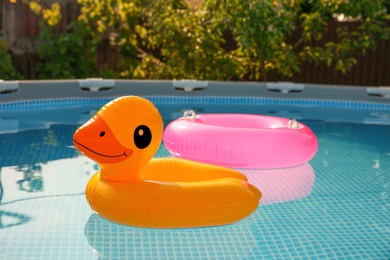 Photo of Inflatable rings on water in above ground swimming pool outdoors