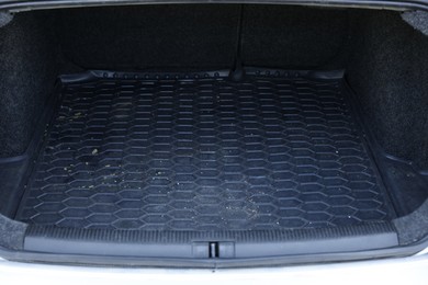 Photo of Black rubber car boot liner mat in trunk of auto