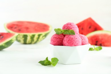 Photo of Scoops of tasty watermelon sorbet with mint in bowl on white table, closeup. Space for text