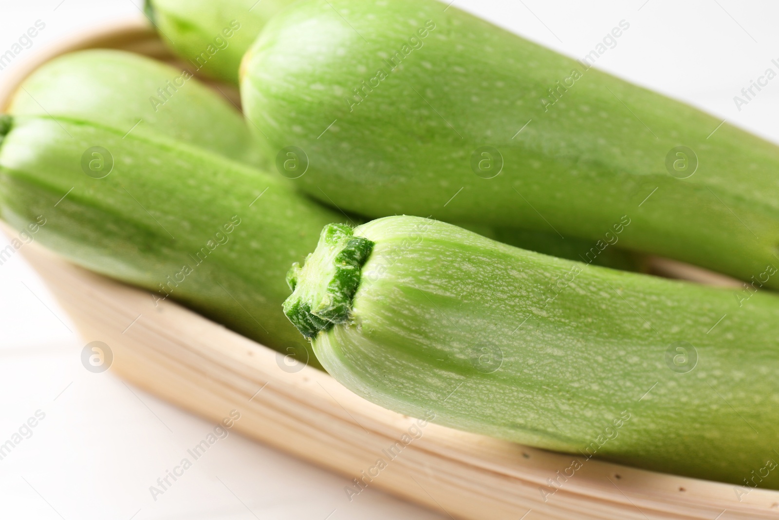 Photo of Fresh ripe zucchinis on white table, closeup