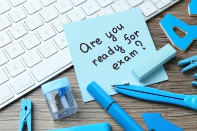 Photo of Note with question Are You Ready For Exam and stationery on wooden desk, closeup