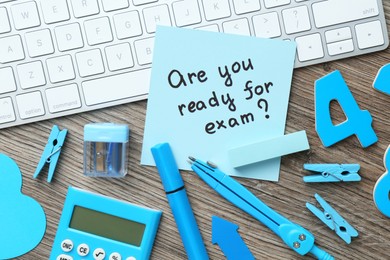 Note with question Are You Ready For Exam and stationery on wooden desk, flat lay