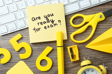 Note with question Are You Ready For Exam and stationery on wooden desk, flat lay