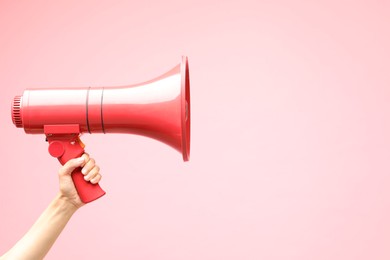 Photo of Woman holding megaphone speaker on pink background, closeup. Space for text