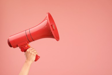 Photo of Woman holding megaphone speaker on pink background, closeup. Space for text