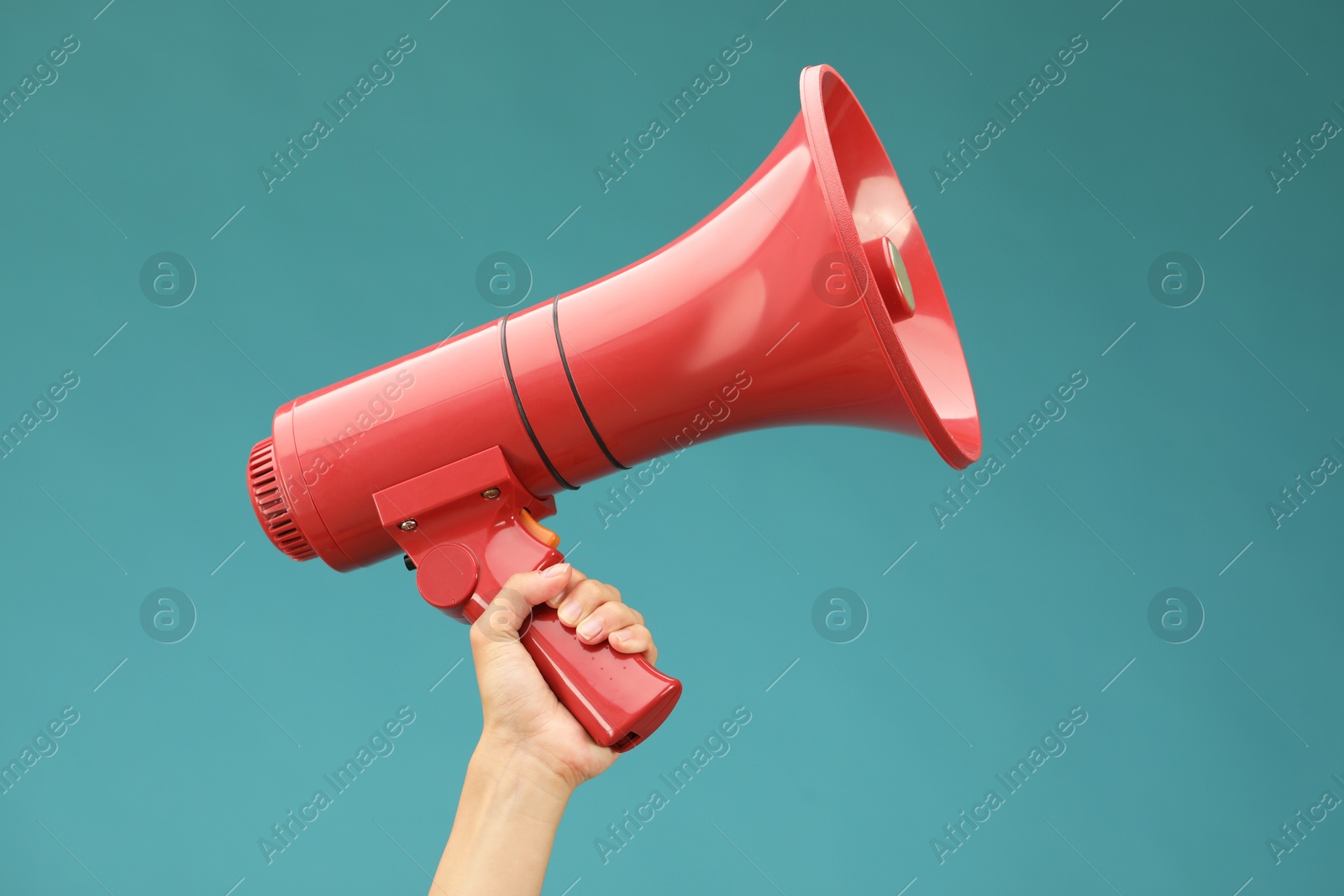 Photo of Woman holding megaphone speaker on blue background, closeup