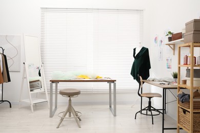 Photo of Fashion designer`s workplace with fabric samples and sewing supplies