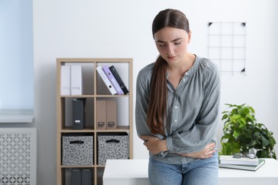 Photo of Woman suffering from menstrual pain in office