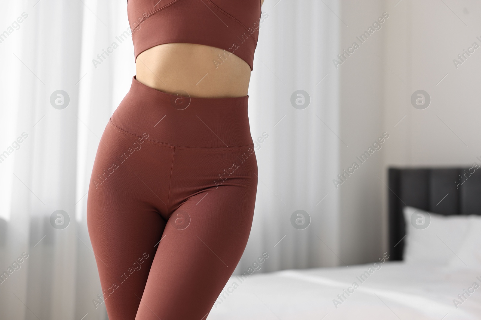 Photo of Woman wearing sports leggings indoors, closeup. Space for text