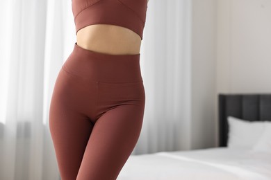 Photo of Woman wearing sports leggings indoors, closeup. Space for text