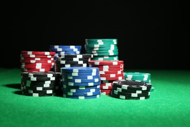 Photo of Poker game. Casino chips on green table, closeup