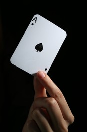 Photo of Woman with playing card against black background, closeup