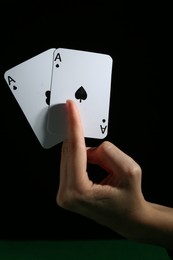 Photo of Woman with playing cards against black background, closeup