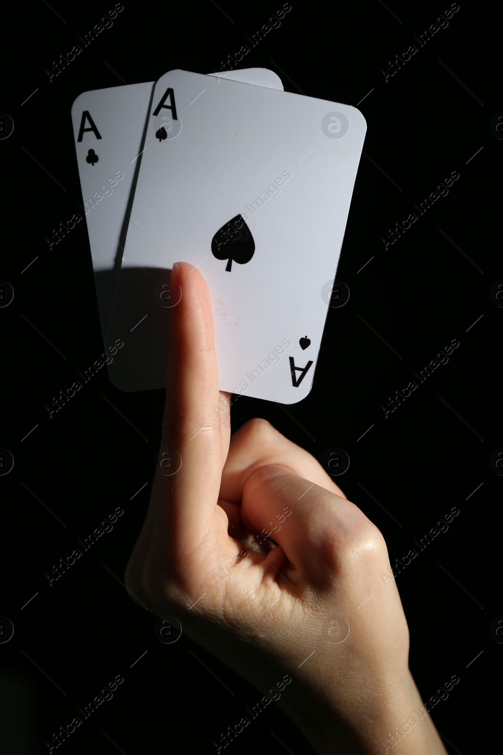 Photo of Woman with playing cards against black background, closeup