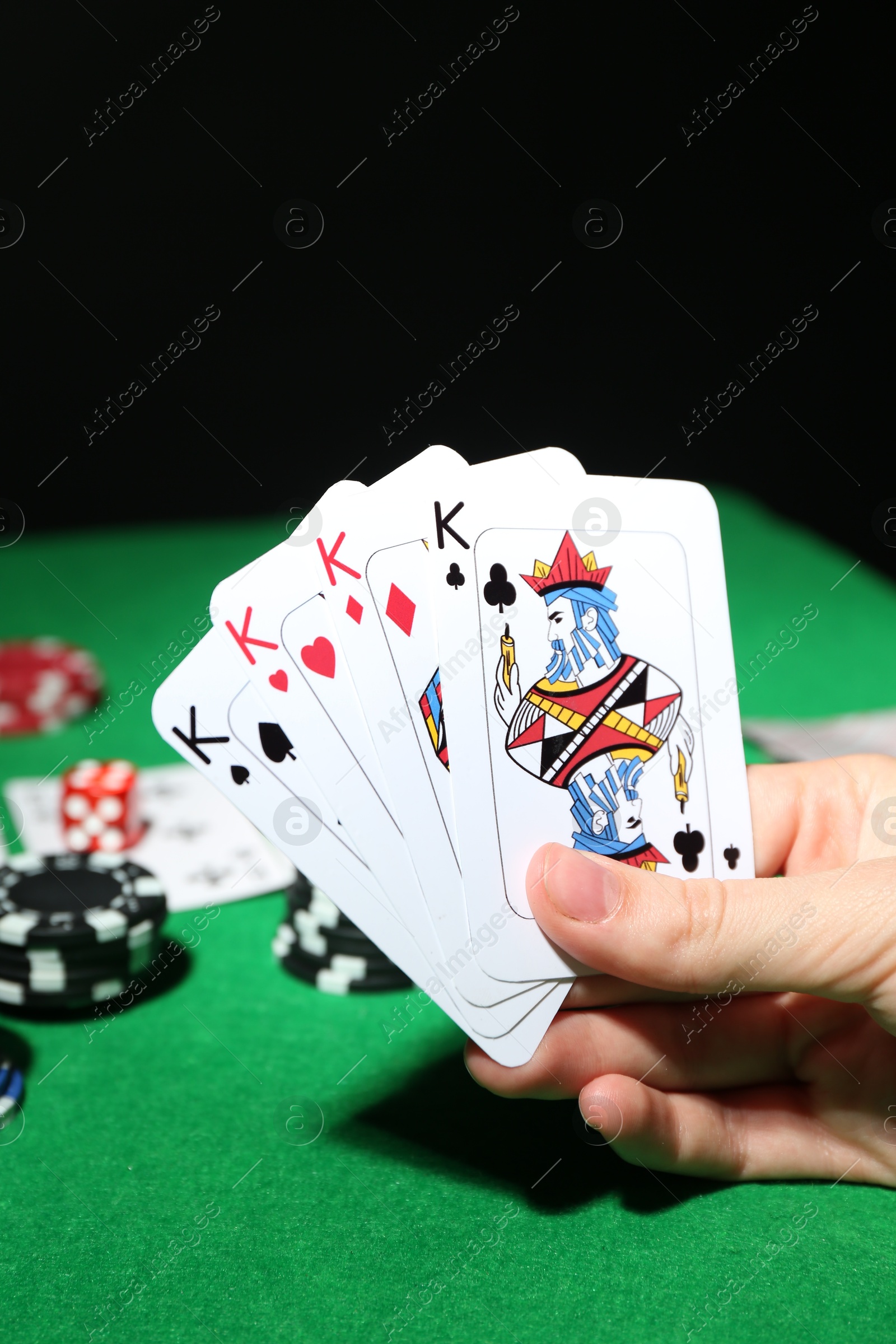 Photo of Poker game. Woman with playing cards at green table, closeup