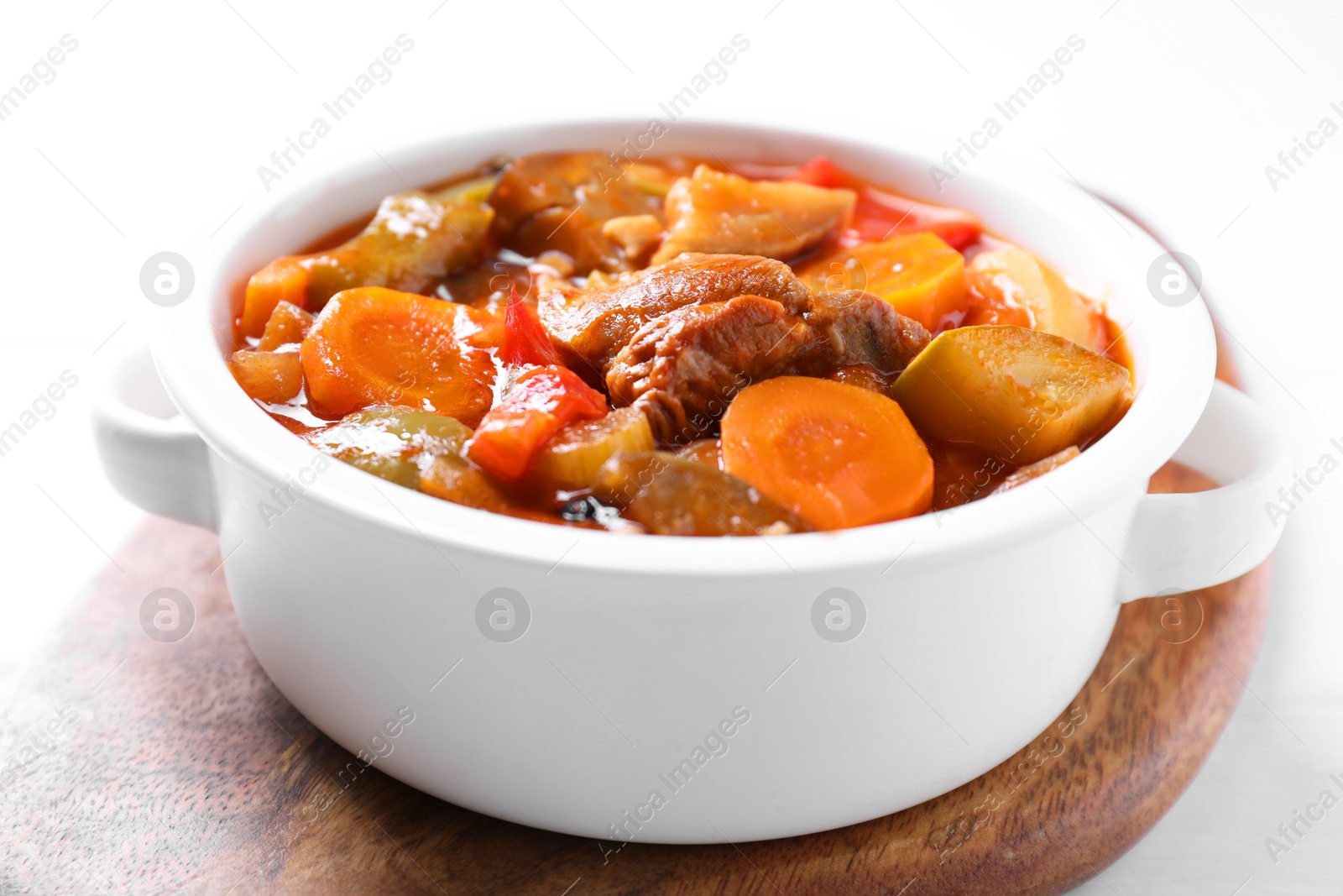 Photo of Delicious stew with vegetables in bowl on white table, closeup