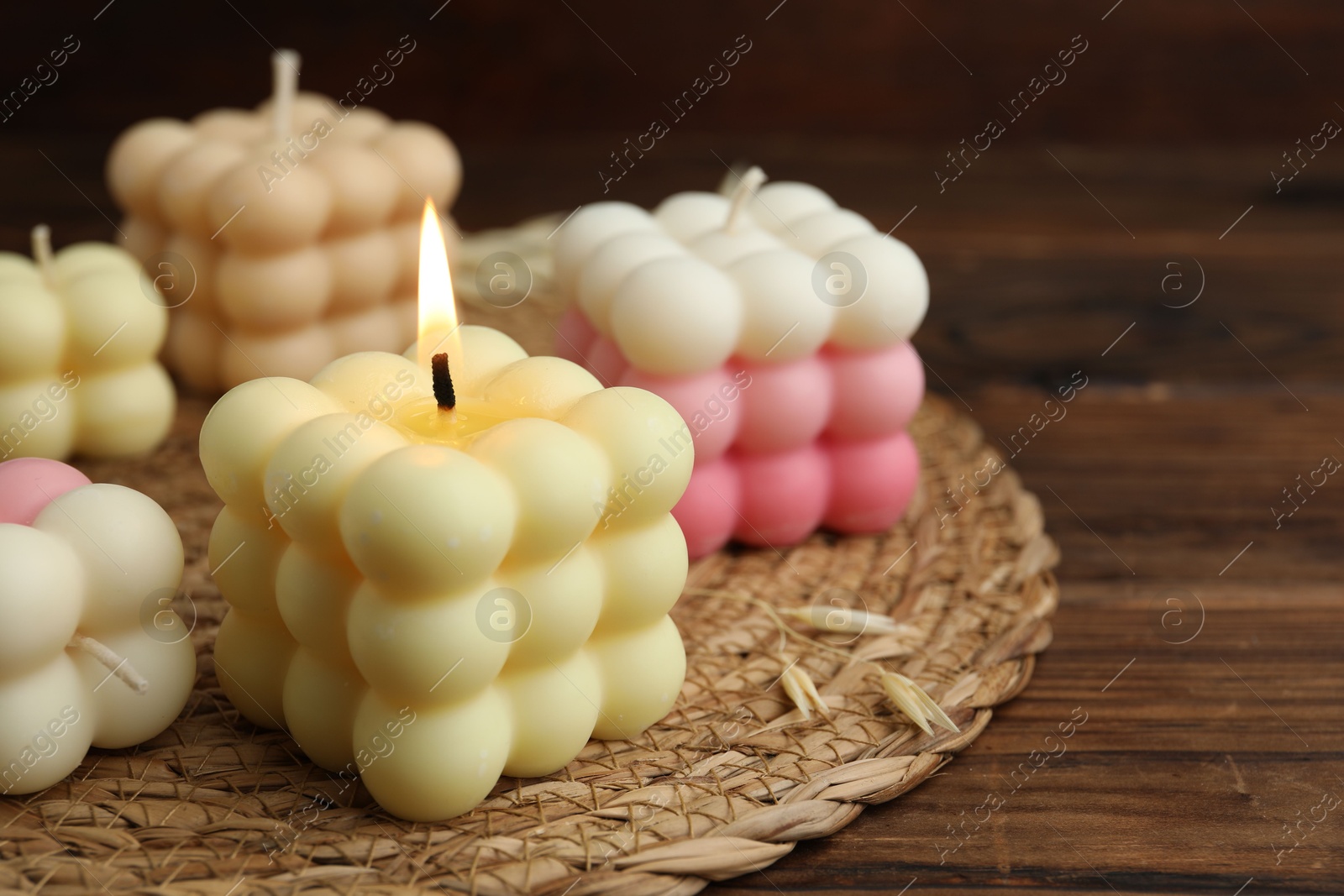 Photo of Different stylish bubble candles on wooden table, closeup. Space for text