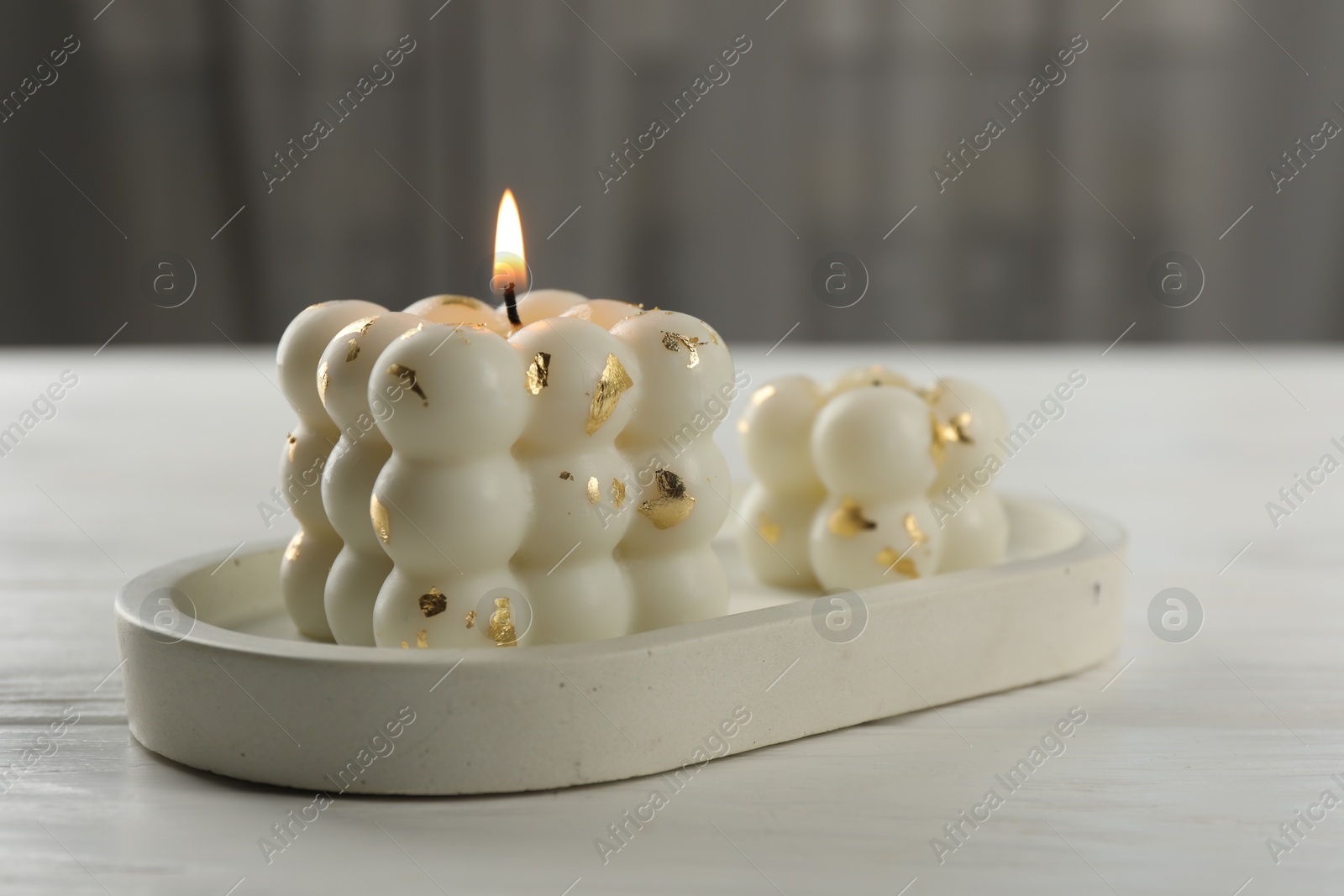 Photo of Stylish bubble candles on white wooden table, closeup