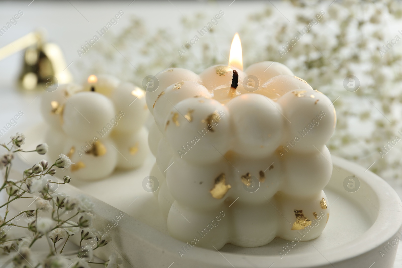 Photo of Stylish bubble candles and gypsophila flowers on table, closeup