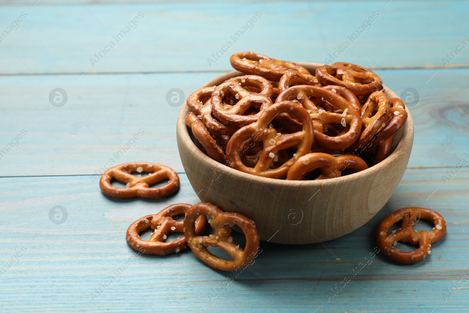 Photo of Delicious pretzel crackers on blue wooden table