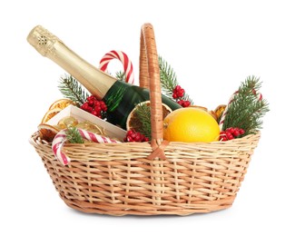 Photo of Wicker gift basket with sparkling wine and Christmas decor isolated on white