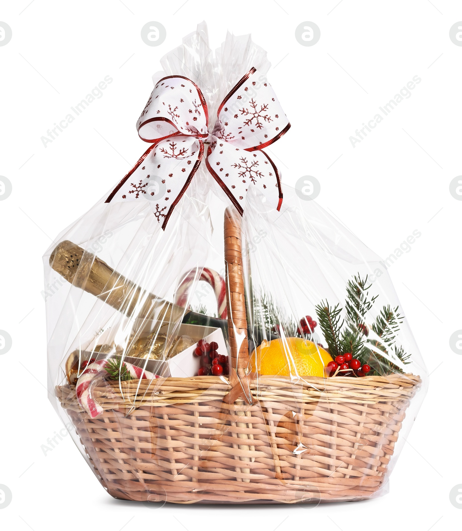 Photo of Wicker gift basket with sparkling wine and Christmas decor isolated on white