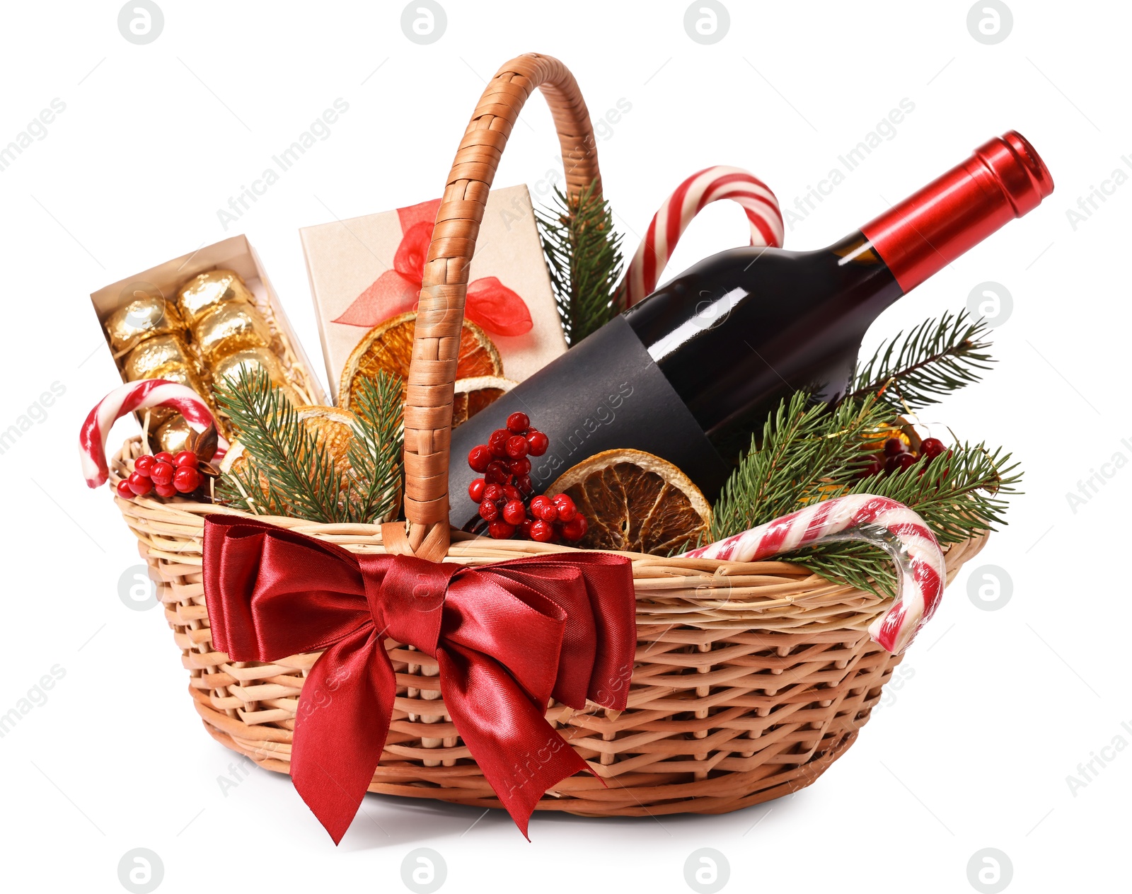 Photo of Wicker gift basket with wine and Christmas decor isolated on white