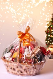 Wicker gift basket with wine on white table