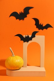 Photo of Halloween celebration. Black paper bats, pumpkin and geometric figures on orange background