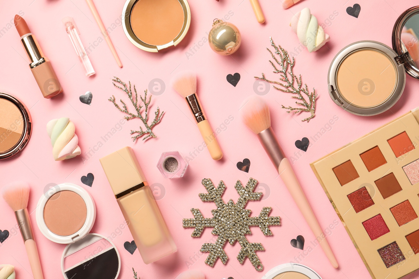 Photo of Different makeup brushes, decorative cosmetics and Christmas decor on pink background, flat lay