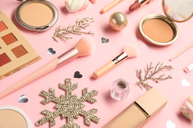 Photo of Different makeup brushes, decorative cosmetics and Christmas decor on pink background