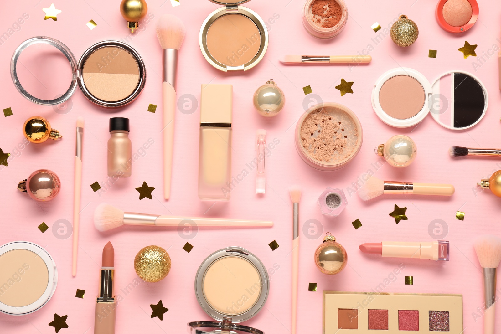 Photo of Different makeup brushes, decorative cosmetics and Christmas decor on pink background, flat lay