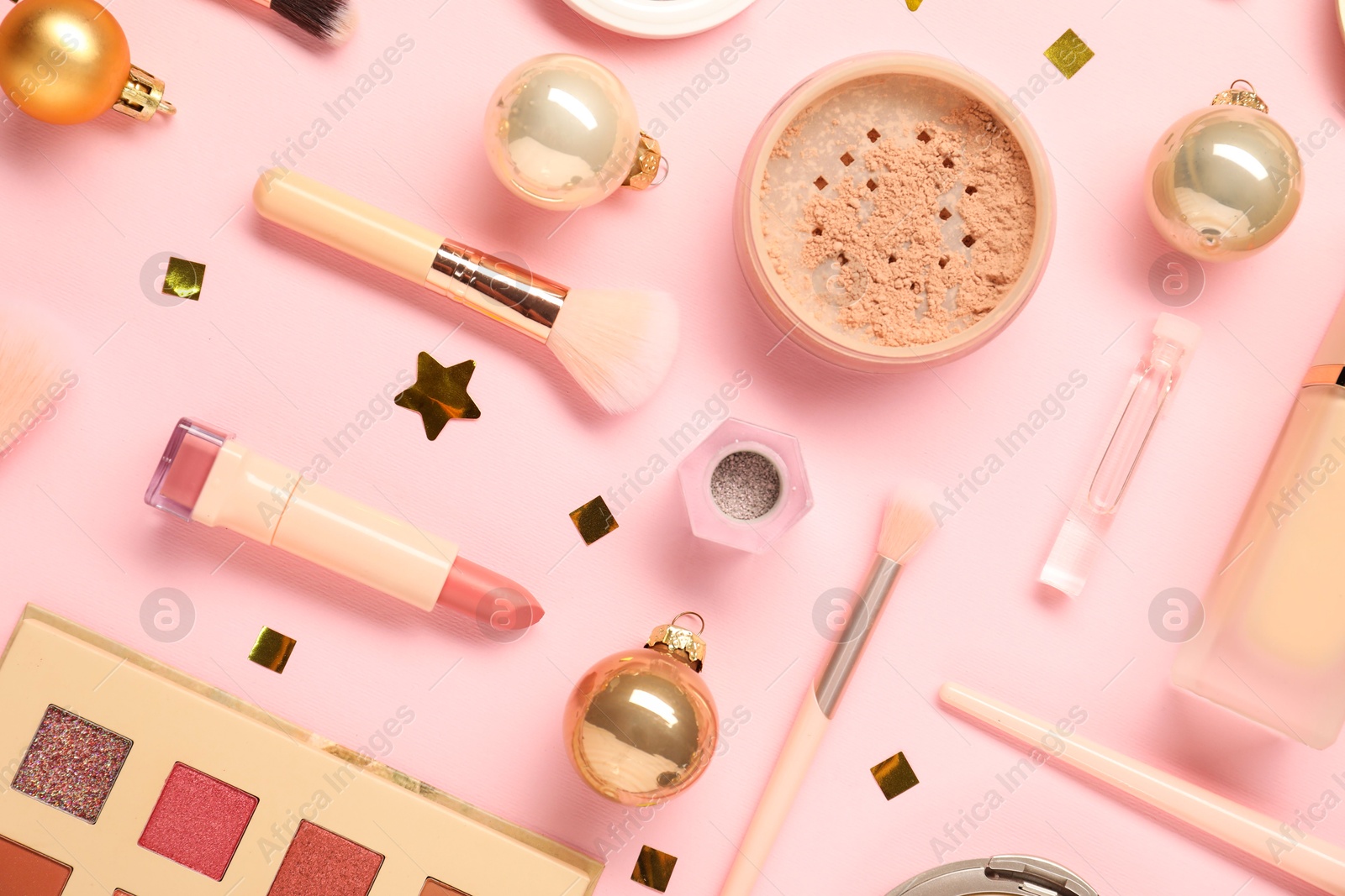 Photo of Different makeup brushes, decorative cosmetics and Christmas decor on pink background, flat lay