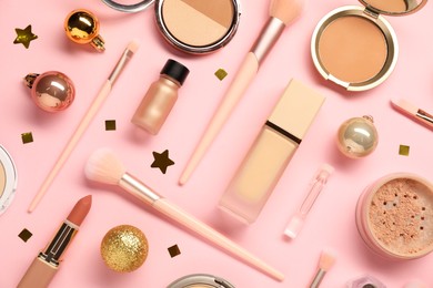 Photo of Different makeup brushes, decorative cosmetics and Christmas decor on pink background, flat lay