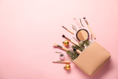 Photo of Different makeup brushes, decorative cosmetics and Christmas decor on pink background, flat lay. Space for text