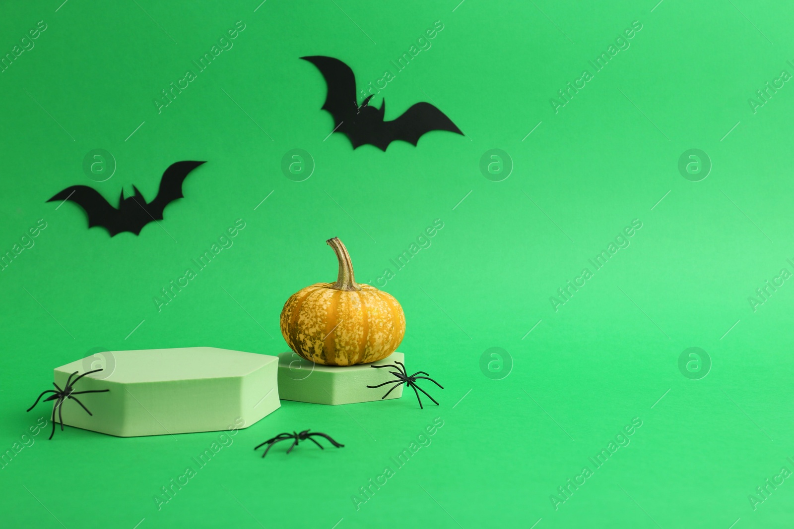 Photo of Presentation of product. Podiums and Halloween decor on green background. Space for text