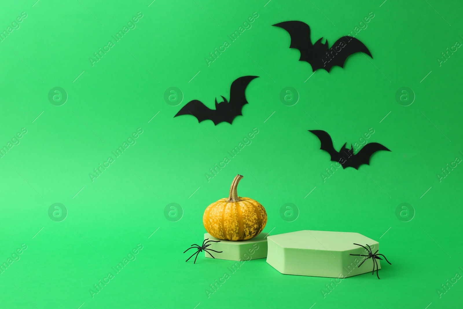 Photo of Presentation of product. Podiums and Halloween decor on green background. Space for text