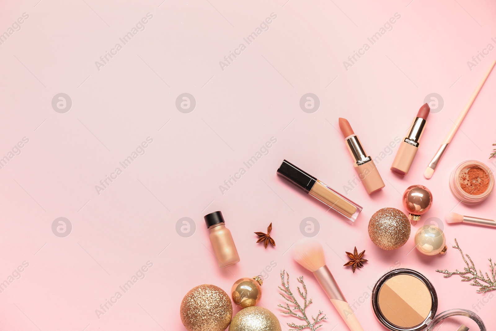 Photo of Different makeup brushes, decorative cosmetics and Christmas decor on pink background, flat lay. Space for text