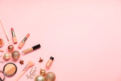 Photo of Different makeup brushes, decorative cosmetics and Christmas decor on pink background, flat lay. Space for text