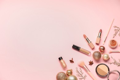 Photo of Different makeup brushes, decorative cosmetics and Christmas decor on pink background, flat lay. Space for text