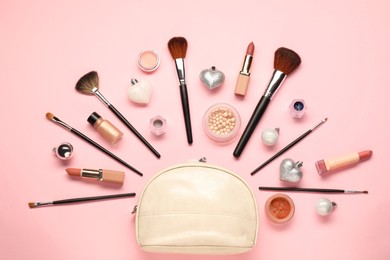 Photo of Cosmetic bag, makeup brushes, decorative cosmetics and Christmas decor on pink background, flat lay